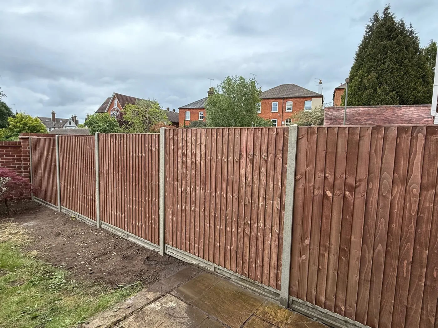 Feather edge fencing with concrete posts and gravel boards in a garden