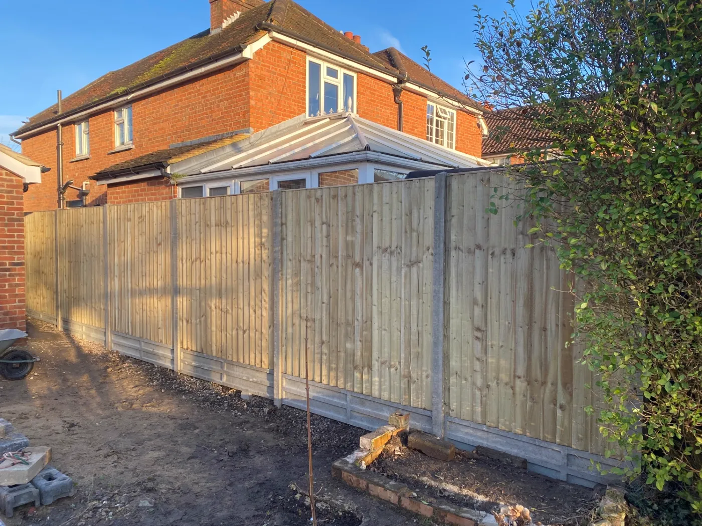 New closeboard fence installation with concrete posts and gravel boards at a family home